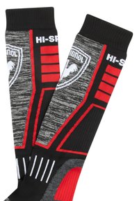 Calze nere e grigie con accenti rossi. Presentano loghi, motivi a righe e trame texturizzate. Lunghezza al ginocchio con polsini a coste.