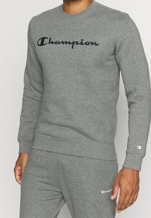 Šedá mikina s černým logem "Champion", žebrovanými manžetami a spodním lemem. Vyrobená z měkkého, strukturovaného materiálu, s klasickým kulatým výstřihem.
