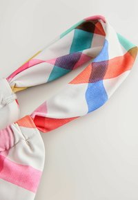 Kolorowa opaska na głowę wykonana z miękkiego materiału, z wzorem geometrycznych kształtów w odcieniach różu, niebieskiego, turkusu i pomarańczy.