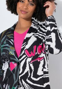 Blazer multicolore con stampa zebra, caratterizzato da un design grafico di un cane, cuori e la parola "WOW!" in rosa. Realizzato in tessuto leggero.