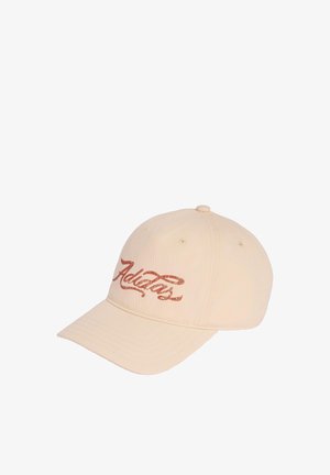 Beige baseball cap with a curved brim and red cursive "Adidas" logo embroidered on the front panel.