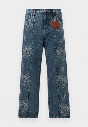Donkerblauwe spijkerbroek met wijde benen, voorzien van witte bloemenborduursels langs de zijkanten. Inclusief een bruine label aan de tailleband.
