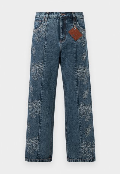 Jeans in denim blu scuro con gambe ampie, caratterizzati da ricami floreali bianchi lungo i lati. Include un'etichetta marrone attaccata alla vita.
