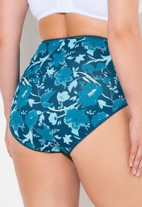 Högmidjade damunderkläder i en marinblå tyg med ett blommönster i nyanser av turkos. Mjuk textur med spetsdetaljer.