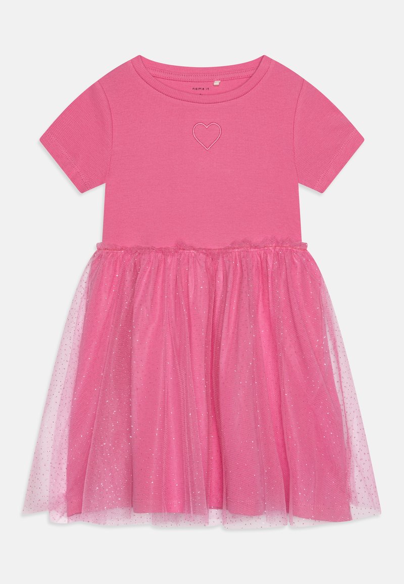 Rochie rosa cu un top cu mânecă scurtă, având broderie în formă de inimă. Fusta are un overlay din tul stratificat cu accente strălucitoare.