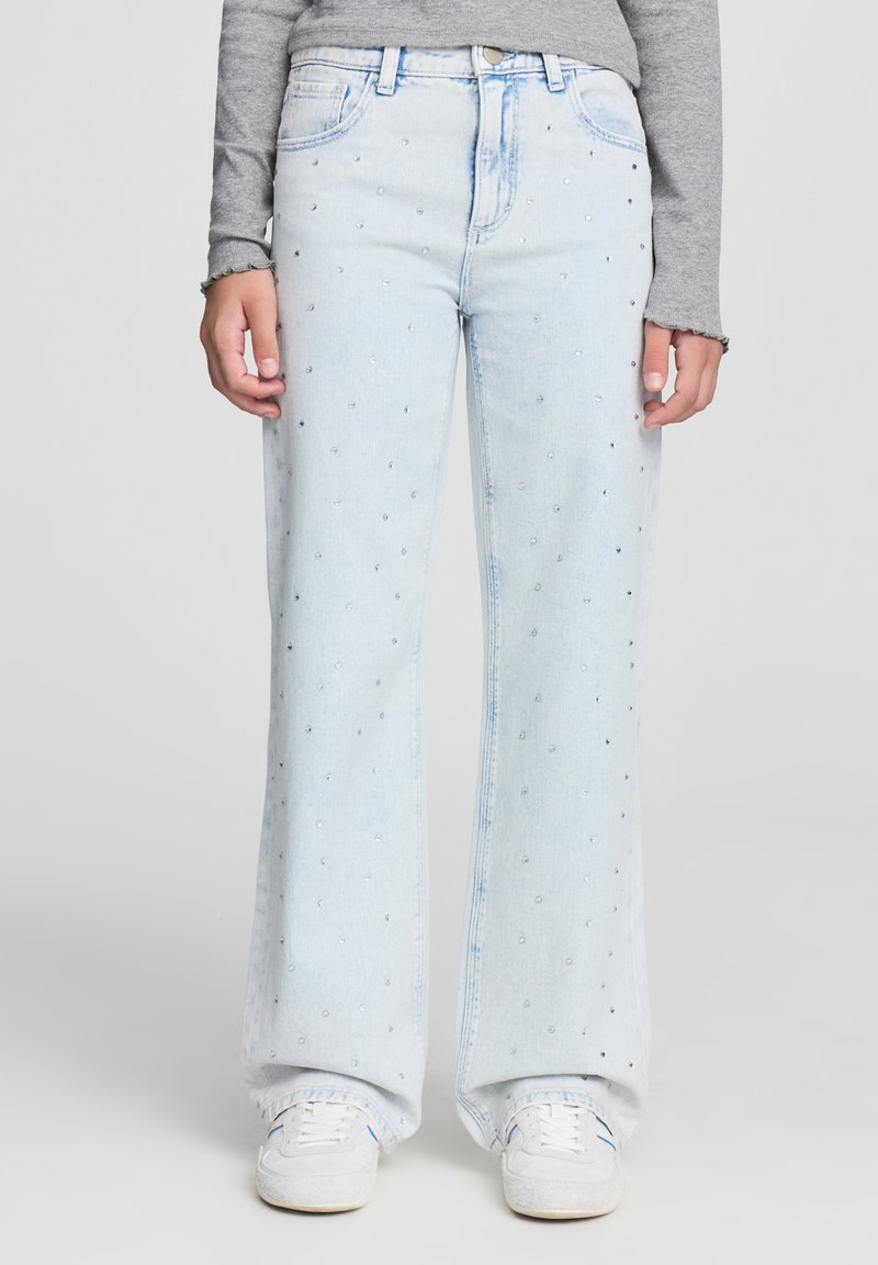 Jeans a gamba larga di un blu chiaro con decorazioni di strass sparse, presentano un classico design a cinque tasche e una chiusura con bottone.