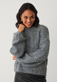 Grauer, strukturierter Pullover mit langen, aufgeblähten Ärmeln und Pailletten, die über die Vorderseite verstreut sind. Gerippter Ausschnitt und Saumdetail. Weiches, gemütliches Material.