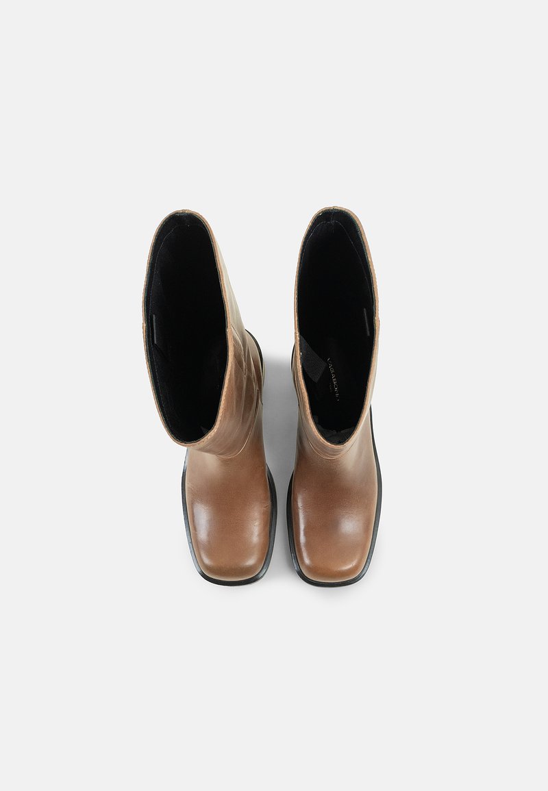 Stivali alla caviglia in pelle marrone con una finitura liscia, punta rotonda e fodera interna nera. Suola in gomma piatta e design minimalista.