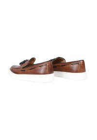 Scarpe slip-on in pelle marrone con accenti neri, suole in gomma bianca e dettagli di cucitura visibili. Design a punta arrotondata.
