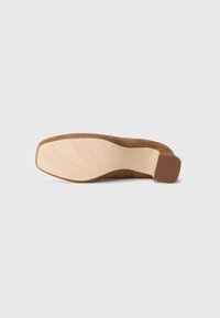 Suela de zapato de ante marrón con acentos de goma, diseño texturizado y tacón plano. Presenta una plantilla suave de color claro con un patrón.