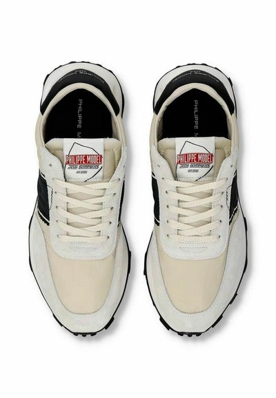 Herresneakers i cremefarvet og sort læder og ruskind. Har en tekstureret sål, flade snørebånd og et logo mærke på tungen.