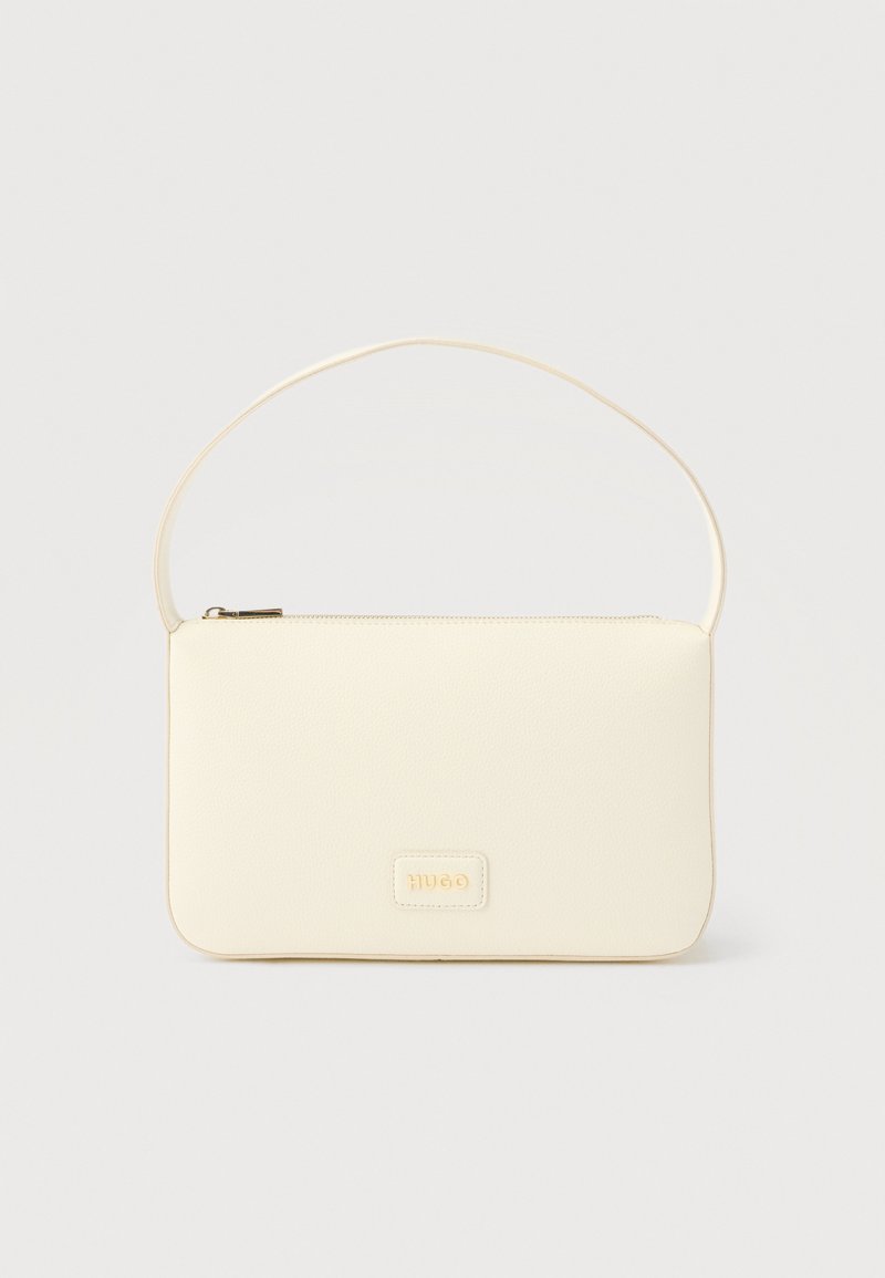 Κρεμ ορθογώνια τσάντα χειρός με ένα λουρί και επάνω φερμουάρ, με μια μικρή ανάγλυφη πλακέτα με λογότυπο στο μπροστινό μέρος.