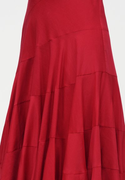 Ροή κόκκινης φούστας με στρώσεις υφασμάτων που δημιουργούν ένα πολυεπίπεδο, υφασματικό σχέδιο.