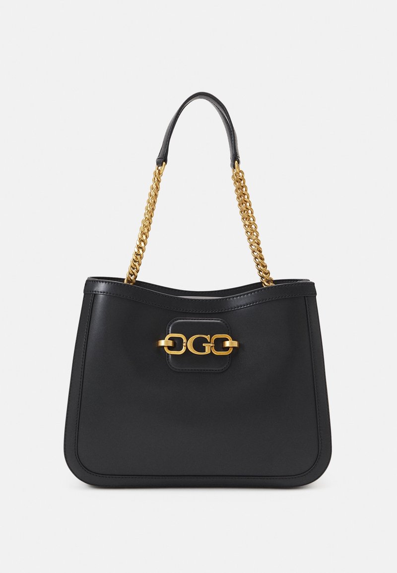 Sac à main en cuir noir avec une bandoulière chaîne dorée et un fermoir décoratif doré à l'avant, sur un fond clair uni.