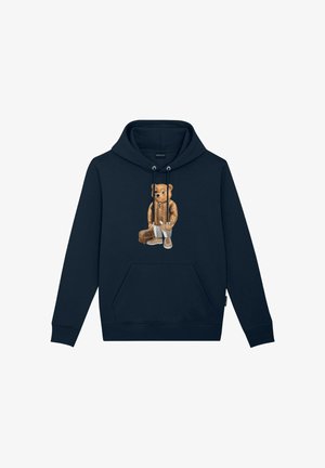 Sudadera con capucha azul marino con un gráfico de un oso que lleva una chaqueta acolchada y sostiene una maleta. Presenta cordones y un bolsillo delantero.