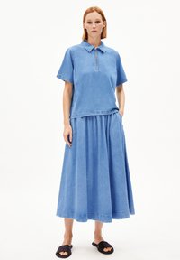 Light blue denim outfit featuring a collared short-sleeve top and a matching long skirt with gathered waist and black slide sandals.