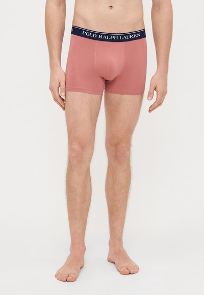 Męskie bokserki z miękkiej różowej bawełny, z granatową elastyczną talią z białym logo "POLO RALPH LAUREN". Długość do połowy uda, dopasowany krój.