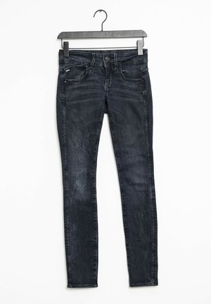 Jean skinny en denim foncé avec une texture lisse, comportant cinq poches, des passants pour ceinture et un léger effet délavé. Fabriqué en tissu denim, avec cintres attachés.