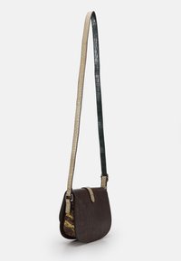 Brązowa skórzana torba crossbody o fakturze krokodyla, z beżowymi i ciemnozielonymi paskami oraz wzorzystą boczną panelą z akcentami wężowego nadruku.