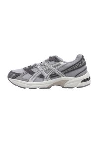Chaussure de sport grise et blanche avec tige en maille, superpositions synthétiques, semelle rembourrée et design texturé pour l'adhérence. Équipée de lacets et de accents de logo.