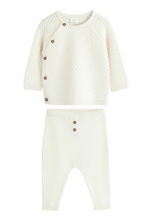 Pull bébé en tricot crème avec motif texturé et pantalon assorti, tous deux avec des boutons marron en accents.