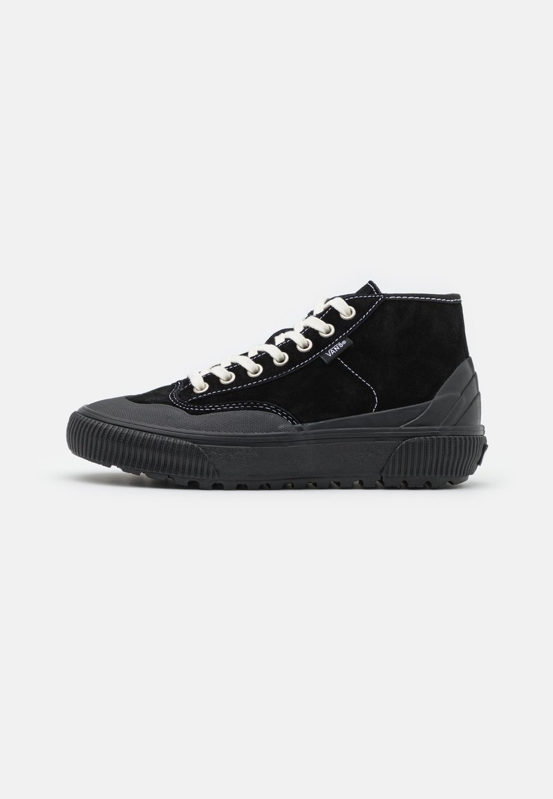 Black high-top sneaker featuring suede and rubber materials, contrasting white laces, and stitch detailing. Textured rubber sole with treads.