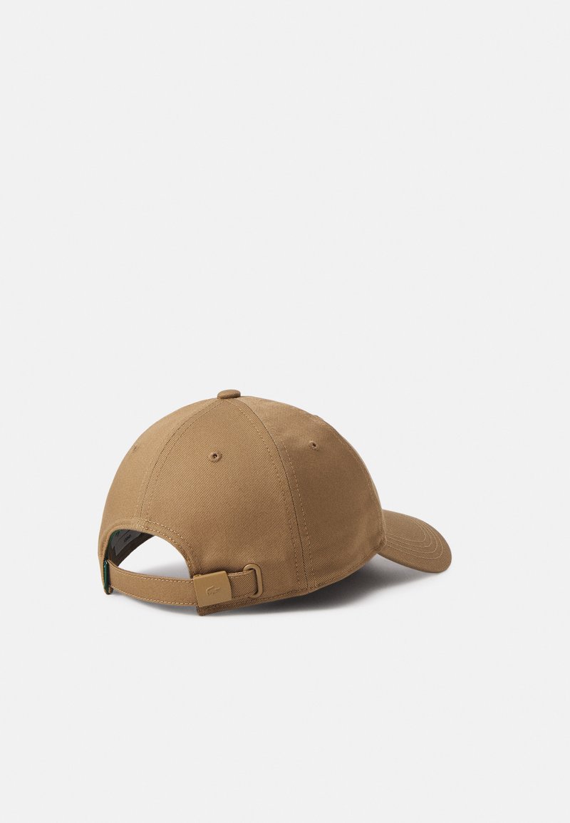 Brauner Baumwoll-Baseballcap mit gebogenem Schirm, abgerundetem Oberteil, verstellbarem Riemen an der Rückseite und kleinem Logo-Detail am Riemen.