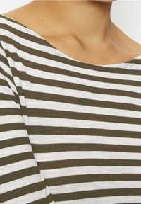 Randig topp med växlande olivgrön och vit horisontella linjer, med bred halsringning och mjukt, texturerat tyg.