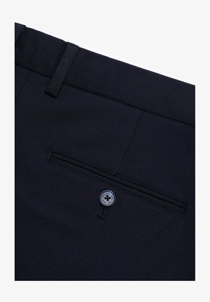 Pantalon bleu marine avec une coupe à plat, une poche arrière avec fermeture à bouton, et un tissu lisse. Présenté en vue de dessus.
