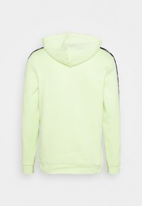 Sweatshirt à capuche en polaire vert citron vif, avec des accents latéraux noirs, des manches longues et une poche kangourou. Texture douce et coupe décontractée.