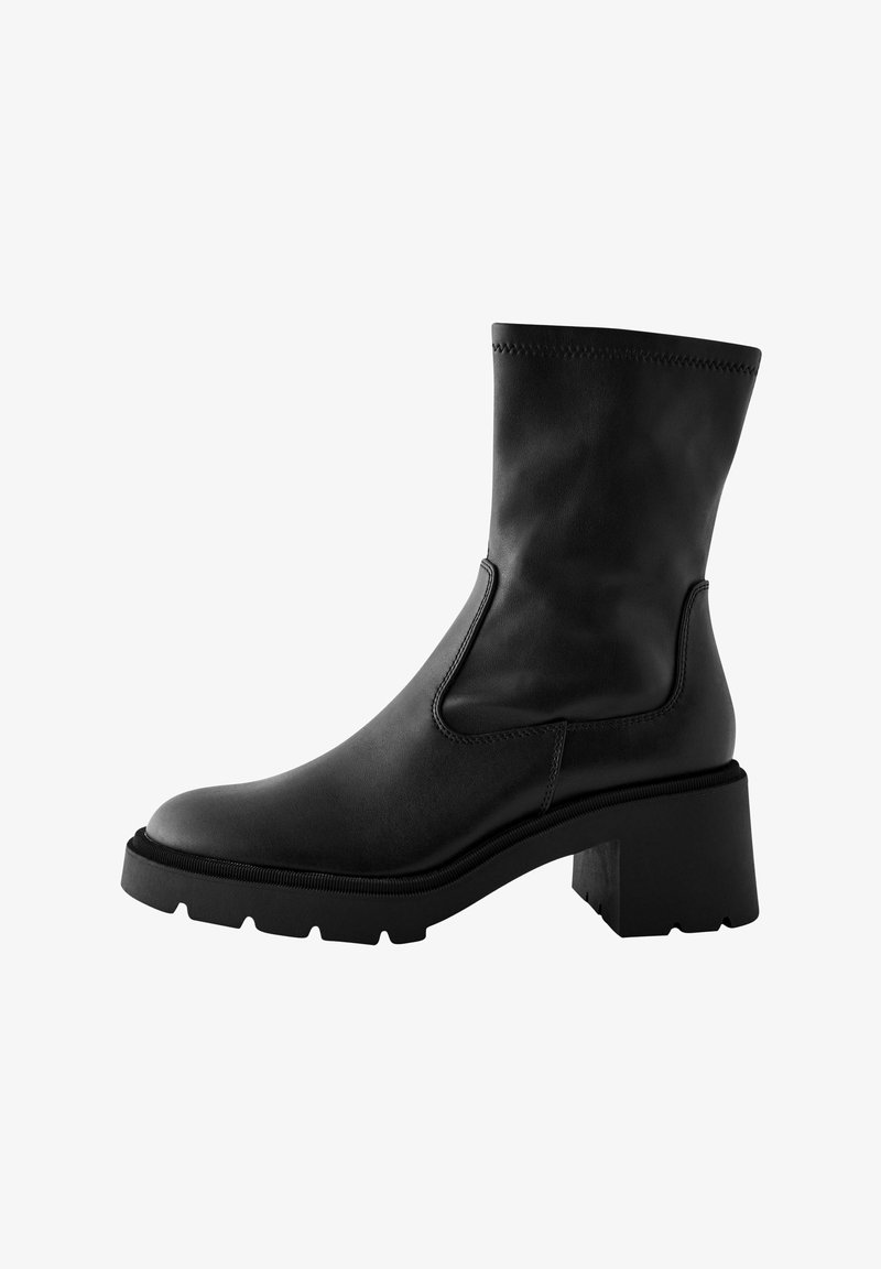 Mustmust musta nahkaste ankle boot'iga, millel on plokk-kukk ja elastsed külgpaneelid. Omab siledat pinna struktuuri ja soonikuid detailide ümber ülemise serva.