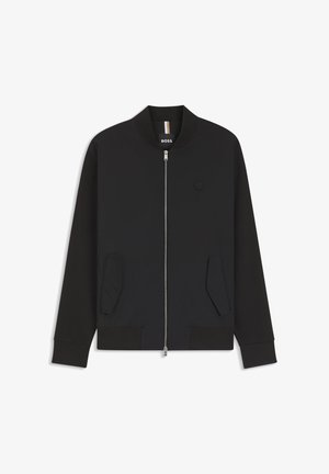 Crna bomber jakna na patentni zatvarač s dva prednja džepa, rebrastim manžetama i ovratnikom te malim okruglim logom na lijevoj strani prsa.