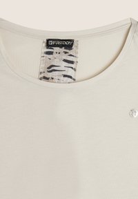 T-shirt beige chiaro con scollo a barca, caratterizzato da un'etichetta con stampa leopardata e un piccolo logo argentato sul fronte, realizzato in tessuto morbido.