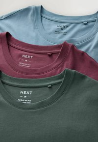Tris crewneck marškinėlių, sudėtinių: šviesiai mėlynas, bordo ir tamsiai žalias. Pagaminti iš minkštos medžiagos, su įprasto dydžio etiketėmis matomomis ant kaklo.