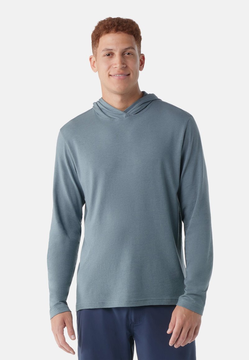 Langärmliger Hoodie aus weichem blauen Stoff mit lässiger Passform, ausgestattet mit einem Überkreuz-Halsausschnitt und ohne sichtbare Muster oder Hardware-Details.