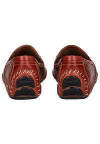 Zapatos de piel roja tipo slip-on con superficie texturizada, costuras en contraste y suelas de goma con un agarre estampado. Diseño de tacón plano.