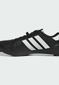 Svart sportskor med meshnät uppdelning, tre vita ränder på sidan och perforerade detaljer. Designad för prestanda med en slank, låg profil.