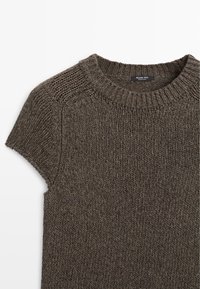 Pull marron en maille à manches courtes avec col et bords de manches côtelés, motif de point texturé, et une petite étiquette de marque à l'intérieur de l'encolure.
