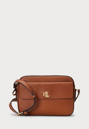Sac bandoulière en cuir marron avec bandoulière réglable et logo doré RLL sur le rabat de la poche avant sur fond uni.