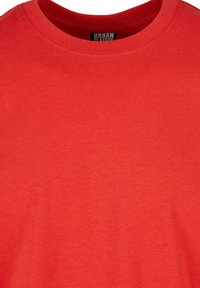 Rotes Baumwoll-T-Shirt mit Rundhalsausschnitt, kurzen Ärmeln und glatter Textur. Das Etikett trägt die Aufschrift "URBAN CLASSICS."