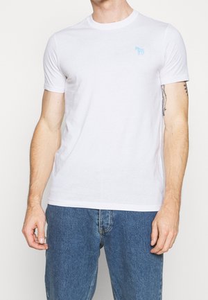 Hvid bomulds t-shirt med korte ærmer, rund halsudskæring og et lyseblåt hestemblem på venstre bryst. Enkel, glat tekstur.