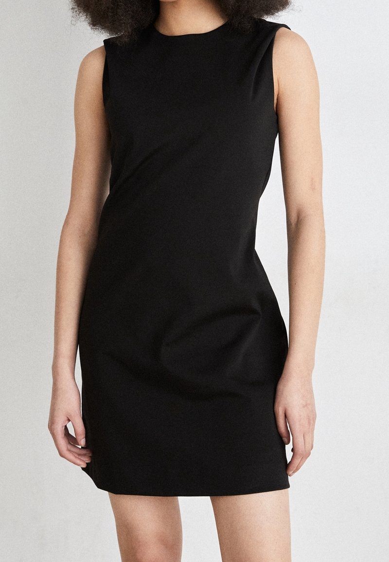 Svart ärmlös klänning i smidigt, elastiskt material. Fitted modell med rund halsringning och minimala sömmar. Enkel och elegant design.