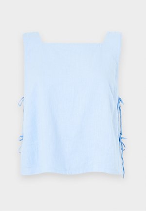 Šviesiai mėlynas lininis viršus su kvadratine iškirpte ir šoninėmis raišteliais. Pasižymi lygia tekstūra ir laisvu, kvadratiniu siluetu. Išskirtinis ir minimalus dizainas.