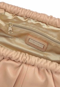 Wnętrze miękkiej różowej skórzanej torebki prezentujące beżową satynową podszewkę, kieszeń na zamek oraz metalową plakietkę z nazwą marki „kazar”.