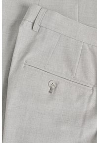 Pantalones de vestir gris claro con una textura suave, frente liso, un bolsillo trasero y cierre de botón con un detalle de cadena trenzada.