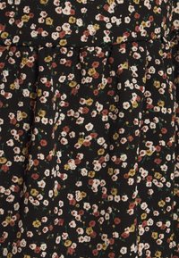 Musta kangas, jossa on kukkakuosi, jossa on valkoisia, vaaleanpunaisia ja keltaisia kukkia. Pukusuunnittelu, jossa on pehmeä rakenne.