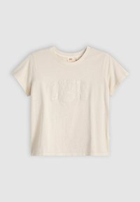 Kermanvärinen puuvillapaidat, jossa on teksturoitu Levi's-logo edessä, pyöreä kaula-aukko ja lyhyet hihat, joissa on käänteet.