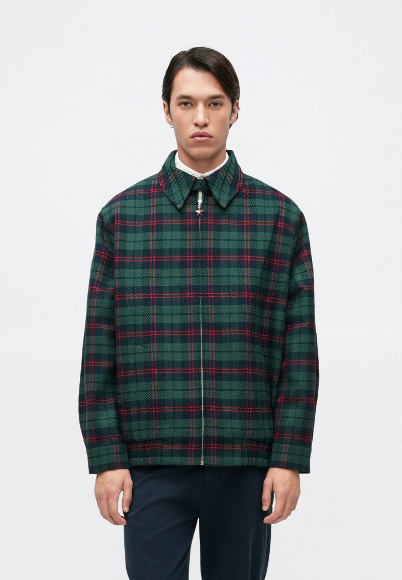 Πράσινο και ναυτικό καρό μπουφάν με κόκκινες λεπτομέρειες, διαθέτει γιακά, μπροστινό φερμουάρ και μακριά μανίκια. Υφασμάτινη υφή με άνετη εφαρμογή.