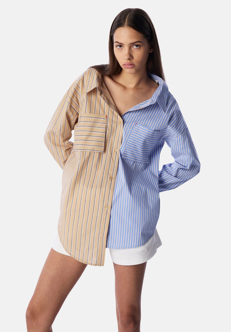 Camicia a righe con un lato beige e righe blu scuro e un lato azzurro con righe azzurre più chiare; due tasche sul petto.