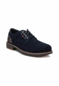 Zapatos de ante azul marino con cordones, punta redonda, tacón marrón en contraste y costuras decorativas. Con ojales de metal y suela texturizada.